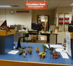 toy dinosaurs on the Library circulation desk